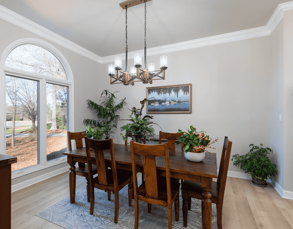 Newly remodeled dining area with a rustic wooden table and modern chandelier by Alexander Realty and Construction LLC